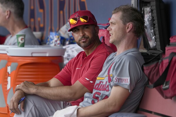 St. Louis Cardinals starting pitcher Sonny Gray, right, talks in the dugout with manager Oliver Marmol after being removed during the second inning of a spring training baseball game against the Washington Nationals Monday, March 4, 2024, in West Palm Beach, Fla. The team announced that Gray was removed due to tightness in his right hamstring. (AP Photo/Jeff Roberson)