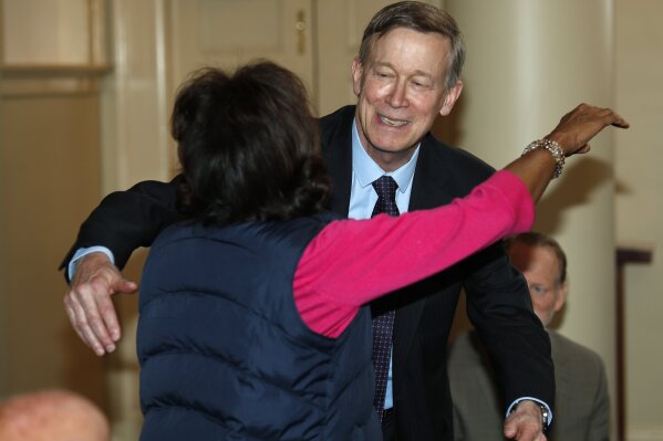 
              Democratic presidential hopeful John Hickenlooper, back, hugs Colorado state Sen. Rhonda Fields, D-Aurora, during a meeting with survivors of victims of mass shootings in Colorado Tuesday, April 16, 2019, in Denver. Fields lost her son and his fiancee in a shooting in 2005. (AP Photo/David Zalubowski)
            
