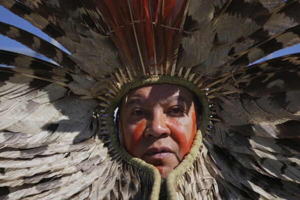Un indígena protesta contra la subasta de docenas de bloques petrolíferos, algunos de ellos ubicados cerca de la desembocadura del río Amazonas, en Río de Janeiro, el 17 de junio de 2025. (AP Foto/Silvia Izquierdo)