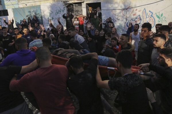 Palestinian women react as a body is carried out from the rubble of a destroyed house following Israeli airstrikes on Gaza City, Saturday, Oct. 21, 2023. (AP Photo/Abed Khaled)