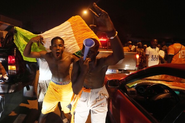 Ivory Coast soccer fans celebrate on a street in Bouake, Ivory Coast after Ivory Coast won the African Cup of Nations quarter final soccer match against Mali, at the Peace of Bouake stadium in Bouake, Ivory Coast, Saturday, Feb. 3, 2024. (AP Photo/Sunday Alamba)