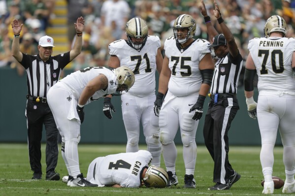 New Orleans Saints quarterback Derek Carr (4) lays on the turf after being hurt while being sacked during the second half of an NFL football game against the Green Bay Packers Sunday, Sept. 24, 2023, in Green Bay, Wis. (AP Photo/Matt Ludtke)