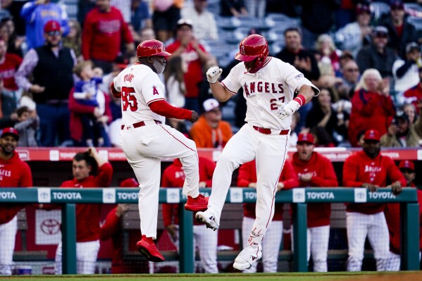 Los Angeles Angels' Mike Trout, right, celebrates his home run with third base coach Eric Young Sr. during the first inning of a baseball game against the Baltimore Orioles, Tuesday, April 23, 2024, in Anaheim, Calif. (AP Photo/Ryan Sun)