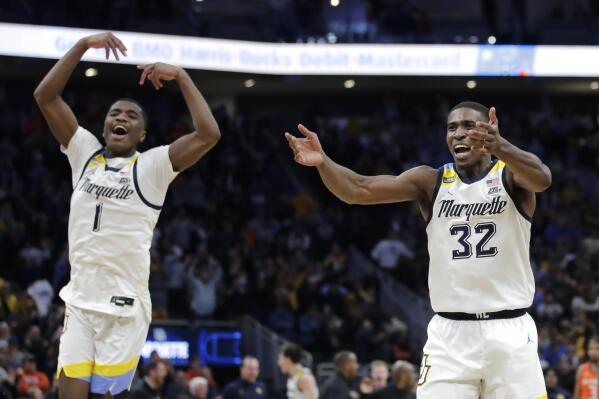 Marquette's Darryl Morsell (32) and Kameron Jones (1) celebrate after the team's 67-66 win over Illinois in an NCAA college basketball game Monday, Nov. 15, 2021, in Milwaukee. (AP Photo/Aaron Gash)
