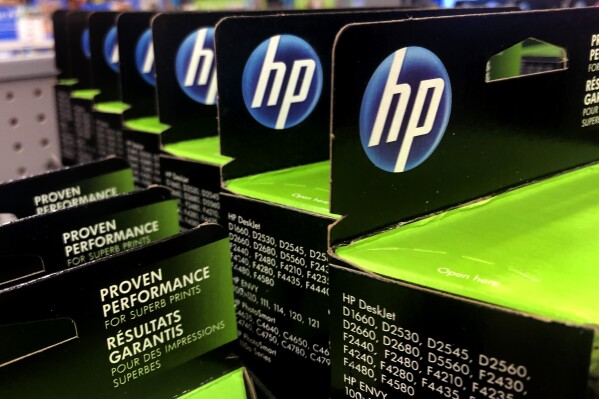 FILE - This Aug. 15, 2019, photo shows the HP logo on Hewlett-Packard printer ink cartridges at a store in Manchester, N.H. HP Inc. has failed to shunt aside claims in a lawsuit that it disables scanners and other functions on its multifunction printers whenever the ink runs low. The suit claims that HP's so-called “all-in-one” printers provide consumers no indication the devices require printer ink to scan documents or send faxes. (AP Photo/Charles Krupa, file)