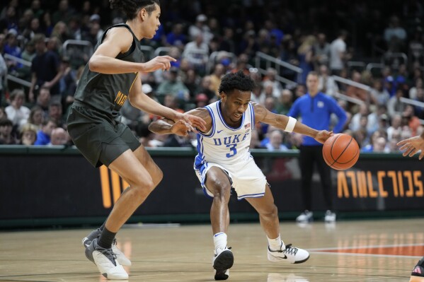 Duke guard Jeremy Roach (3) drives to the basket against Miami guard Kyshawn George (7) during the first half of an NCAA college basketball game, Wednesday, Feb. 21, 2024, in Coral Gables, Fla. (AP Photo/Wilfredo Lee)