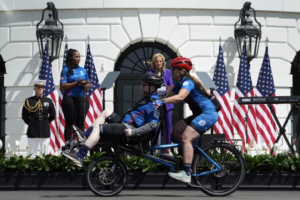 First lady Jill Biden, in purple, and Sharona Young, retired naval chief petty officer, second from left, watch as wounded warrior riders begin the Wounded Warrior Project's Soldier Ride on the South Lawn of the White House in Washington, Wednesday, April 24, 2024. (AP Photo/Susan Walsh)