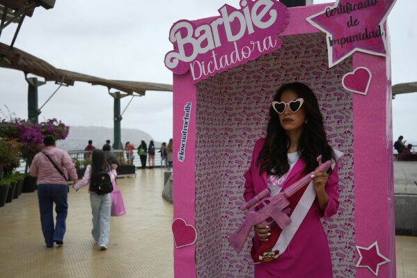 An anti-government protester, dressed as Barbie holding a fake gun, takes part in a demonstration demanding that Peruvian President Dina Boluarte call for immediate presidential elections as well as justice for those who were killed during protests earlier this year after the ouster of her predecessor, in Lima, Peru, Saturday, July 22, 2023. (AP Photo/Martin Mejia)
