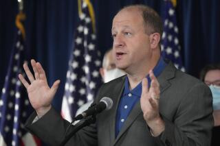 Colorado Gov. Jared Polis makes a point during a news conference about Colorado offering coronavirus vaccinations to children, Thursday, Oct. 28, 2021, in Denver. Colorado is also seeing an increase in overall coronavirus cases, which is putting stress on the state's hospital systems. (AP Photo/David Zalubowski)