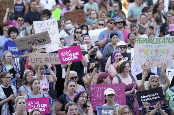 FILE - Abortion rights protesters attend a rally outside the state Capitol in Lansing, Mich., June 24, 2022, following the United States Supreme Court's decision to overturn Roe v. Wade. Two key pieces of legislation that would have repealed a 24-hour wait period required for patients receiving an abortion and also allowed state Medicaid dollars to pay for abortions were left out of a package signed Tuesday, Nov. 21, 2023, by Gov. Gretchen Whitmer. (AP Photo/Paul Sancya, File)