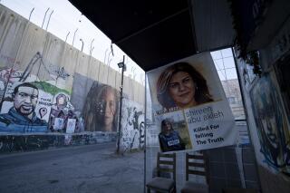 Slain Palestinian-American journalist Shireen Abu Akleh is depicted in a poster at right, near murals of George Floyd, left, a Black American killed by police in Minneapolis in 2020, and Palestinian activist Ahed Tamimi, center, on Israel's controversial separation barrier in the West Bank town of Bethlehem, Sunday, June 19, 2022. (AP Photo/Maya Alleruzzo)