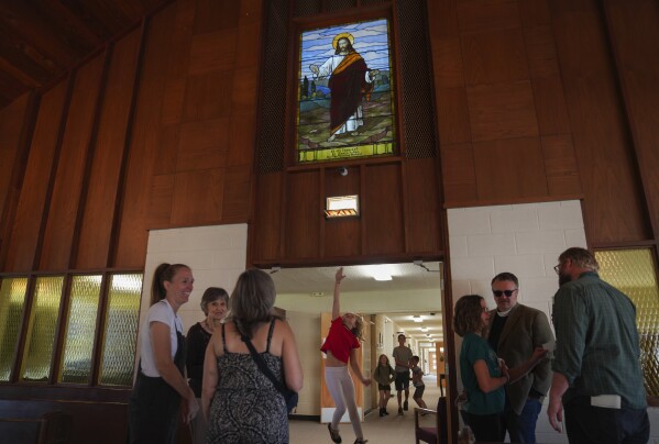 A young girl jumps to touch the doorway to the sanctuary of First Baptist Church in Mt. Vernon, Ill., Sunday, Sept. 10, 2023. (AP Photo/Jessie Wardarski)