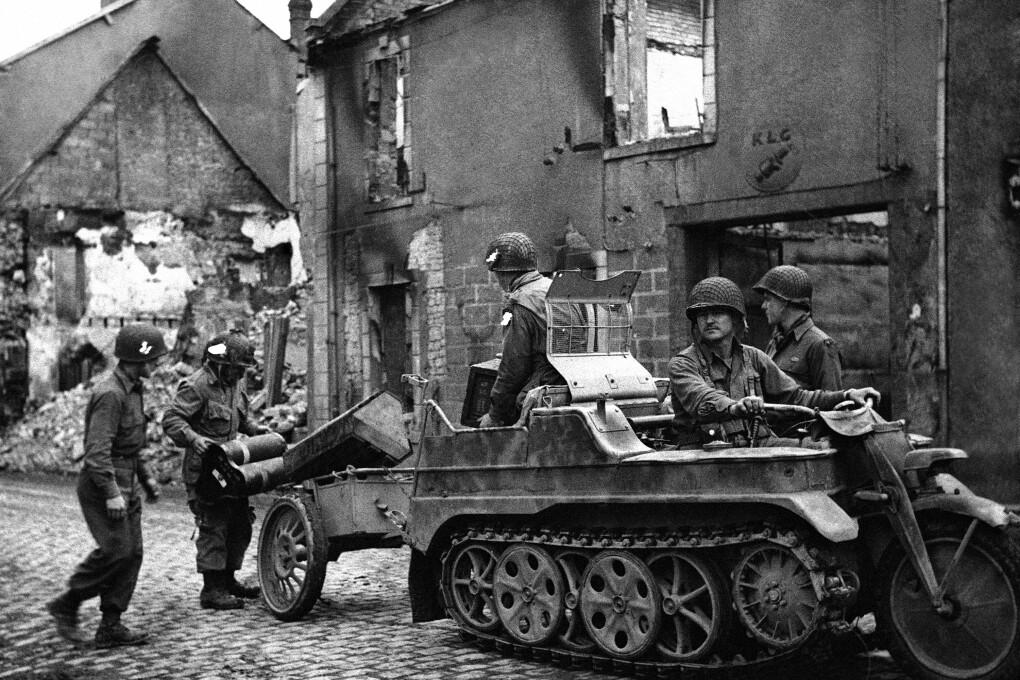 FILE - Men of an airborne unit use a German half-track motor-cycle to carry their ammunition and supplies in the Carontan area of Normandy on June 17, 1944. (AP Photo, File)