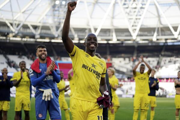 Brentford forward Yoane Wissa celebrates with supporters after winning an English Premier League soccer match against West Ham United at London Stadium in London, Sunday, Oct. 3, 2021. Brentford won 2-1. (AP Photo/Steve Luciano)
