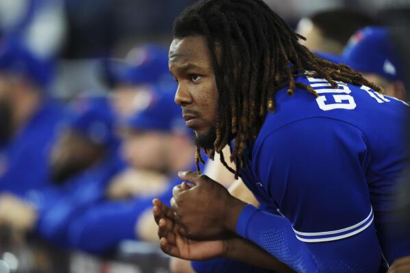 Toronto Blue Jays first baseman Vladimir Guerrero Jr. (27) looks on from the dugout as they face the Seattle Mariners during the ninth inning of Game 2 of a baseball AL wild-card playoff series, Saturday, Oct. 8, 2022, in Toronto. (Nathan Denette/The Canadian Press via AP)