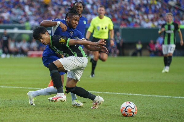 Brighton's Kaoru Mitoma, left, loses control of the ball as Chelsea's Christopher Nkunku, right, goes after it during the first half of an English Premier League Summer Series soccer match between Chelsea and Brighton and Hove Albion, Saturday, July 22, 2023 in Philadelphia. (AP Photo/Chris Szagola)