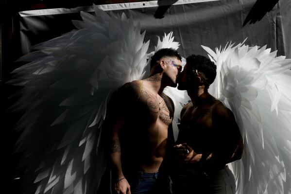 Men donning angel wings share a kiss in downtown Buenos Aires, Argentina, where thousands gathered to commemorate the 32nd annual Pride Parade on Nov. 4, 2023. (AP Photo/Rodrigo Abd)