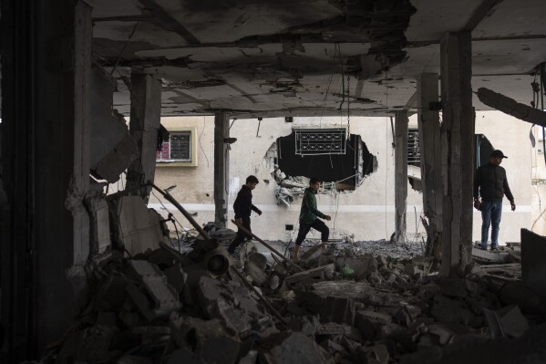 Palestinians look at the destruction after an Israeli airstrike in Rafah, Gaza Strip, Friday, Feb. 9, 2024. (APPhoto/Fatima Shbair)