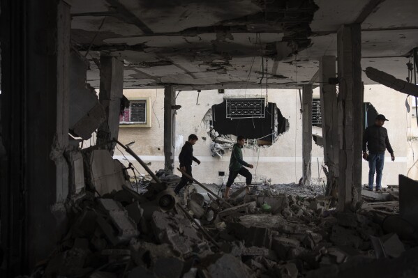 Palestinians look at the destruction after an Israeli airstrike in Rafah, Gaza Strip, Friday, Feb. 9, 2024. (AP Photo/Fatima Shbair)