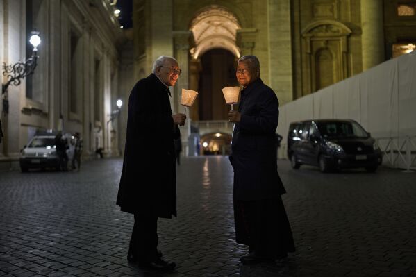 Cardinal Dean Giovanni Battista Re, left, and Cardinal Lazarus You Heung-sik talk before attending a rosary prayer and a candlelight procession with the image of Mater Ecclesiae in St. Peter's Square at the Vatican, Saturday, May 3, 2025. (AP Photo/Bernat Armangue)