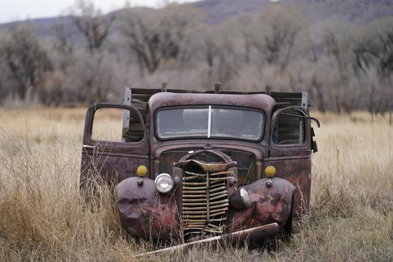 A truck rest in a field near the Wyman Museum on Friday, Nov. 19, 2021, in Craig, Colo. The town in northwest Colorado is losing its coal plant, and residents fear it is the beginning of the end for their community. (AP Photo/Rick Bowmer)