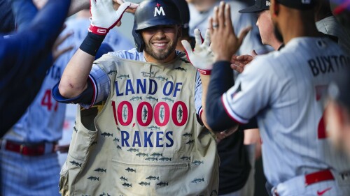 Minnesota Twins' Alex Kirilloff wears a fishing vest in the dugout to celebrate his two-run home run against the Seattle Mariners during the third inning of a baseball game, Tuesday, July 18, 2023, in Seattle. (AP Photo/Lindsey Wasson)