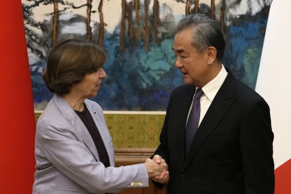 Chinese Foreign Minister Wang Yi, right, shakes hands with French Foreign Minister Catherine Colonna at the Diaoyutai State Guesthouse in Beijing, Friday, Nov. 24, 2023. (AP Photo/Ng Han Guan)