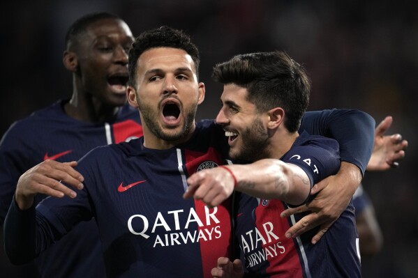 PSG's Lucas Beraldo, left, celebrates with PSG's Goncalo Ramos after scoring his sides second goal during the French League One soccer match between Paris Saint-Germain and Lyon at the Parc des Princes stadium in Paris, Sunday, April 21, 2024. (AP Photo/Christophe Ena)