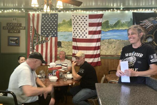 Pauline Bauer, right, speaks with customers from left, Ron Stevenson, 68, of Jamestown, N.Y., his cousin Glenn Robinson, 68, of Kane, Pa., and his half-brother Paul Boedecker, 71, of Warren, Pa., at Bauer’s restaurant, Bob’s Trading Post, Wednesday,  July 21, 2021, in Hamilton, Pa. Bauer is one of more than 540 people charged with federal crimes stemming from the Jan. 6 riot at the U.S. Capitol.  (AP Photo/Michael Kunzelman)