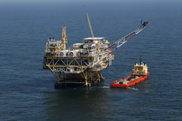 FILE - A rig and supply vessel are viewed in the Gulf of Mexico off the cost of Louisiana, April 10, 2011. A sale of federal Gulf of Mexico oil and gas leases that had been scheduled for Wednesday, Nov. 8, 2023, was officially postponed by the Biden administration on Thursday, Nov. 2. (AP Photo/Gerald Herbert, File)