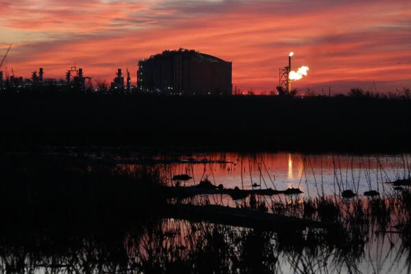 A flare burns at Venture Global LNG in Cameron, La., on Friday, April 21, 2022. The new facility, which exports liquefied natural gas, is one of several like it along the Gulf Coast — and there are proposals for several more in Louisiana and Texas. Natural gas from the Permian Basin in Texas and other areas is sent by pipeline to the export facilities. It is then cooled and liquefied, making it possible to send much greater quantities by ship to Asia, Europe and other places that are hungry for natural gas. (AP Photo/Martha Irvine)