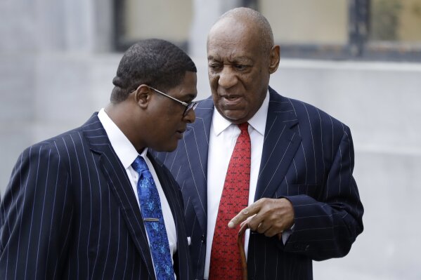 
              Bill Cosby, right, talks with his spokesperson, Andrew Wyatt, as they arrive for a pretrial hearing in Cosby's sexual assault case, Friday, March 30, 2018, at the Montgomery County Courthouse in Norristown, Pa. (AP Photo/Matt Slocum)
            
