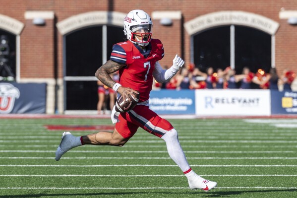 Liberty's Kaidon Salter runs the ball for a touchdown past UMass' Jerry Roberts Jr. during the first half of an NCAA college football game, Saturday, Nov. 18, 2023, in Lynchburg, Va. (AP Photo/Robert Simmons)