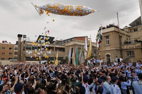Members of the Greek Orthodox Church in Syria march to mark Palm Sunday in the predominantly Christian al-Qassaa neighborhood of Damascus, Syria, Sunday, April 13, 2025. (AP Photo/Omar Sanadiki)