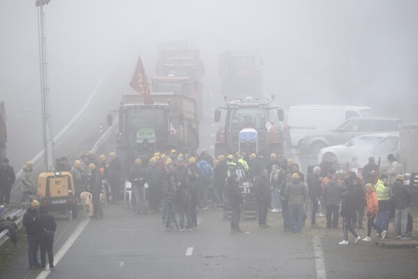 Farmers block a highway, near Agen, southwestern France, Saturday, Jan. 27, 2024. French farmers have vowed to continue protesting and are maintaining traffic barricades on some of the country's major roads. The government announced a series of measures Friday but the farmers say these do not fully address their demands. (AP Photo/Fred Scheiber)
