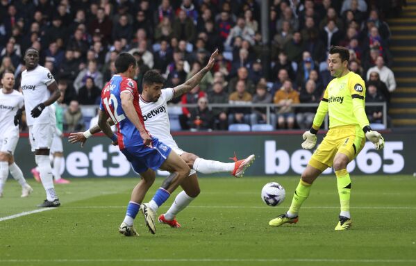 West Ham United's Emerson Palmieri, center, scores an own goal to give Crystal Palace their third goal of the game during the English Premier League soccer match between West Ham United and Crystal Palace at Selhurst Park, London, Sunday April 21, 2024. (Steven Paston/PA via AP)
