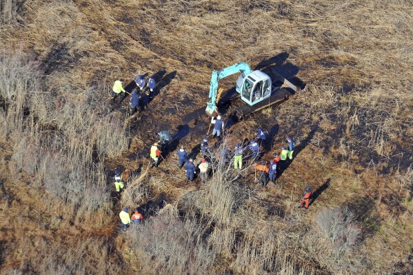 FILE - In this Dec. 8, 2011 photo, investigators use a backhoe to dig while searching for Shannan Gilbert's body in different sectors of a marsh area just east of Oak Beach, N.Y. A Long Island architect has been charged, Friday, July 14, 2023, with murder in the deaths of three of the 11 victims in a long-unsolved string of killings known as the Gilgo Beach murders. (AP Photo/Kevin P. Coughlin, File)