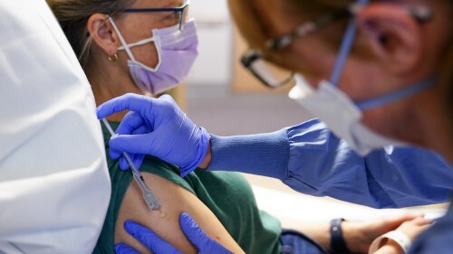 Registered nurse Erika Obrietan administers the third dose of an experimental breast cancer vaccine to patient Kathleen Jade at University of Washington Medical Center - Montlake, Tuesday, May 30, 2023, in Seattle. Jade, 50, learned she had breast cancer in late February. She's getting the vaccine to see if it will shrink her tumor before surgery. “Even if that chance is a little bit, I felt like it’s worth it," said Jade, who is also getting standard treatment. (AP Photo/Lindsey Wasson)