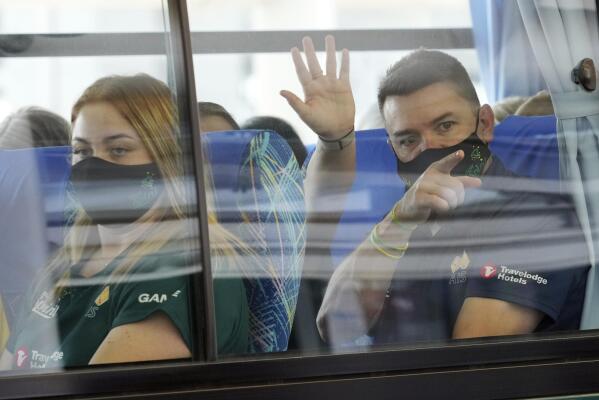 Australia's Olympic softball squad board a bus upon arrival at Narita international airport, Tuesday, June 1, 2021, in Narita, east of Tokyo. Australia’s Olympic softball squad touched down in Japan on Tuesday and was among the earliest arrivals for the Tokyo Games.(AP Photo/Eugene Hoshiko, Pool)