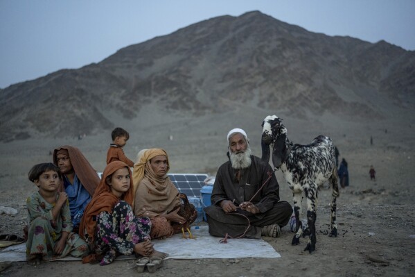 Afghan refugees sit in a camp near the Pakistan-Afghanistan border, in Torkham Afghanistan, Friday, Nov. 3, 2023. Many Afghan refugees arrived at the Torkham border to return home shortly before the expiration of a Pakistani government deadline for those who are in the country illegally, or face deportation. (AP Photo/Ebrahim Noroozi)