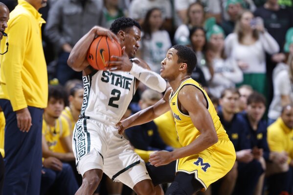 Michigan State guard Tyson Walker (2), left, is pressured by Michigan guard Nimari Burnett during the first half of an NCAA college basketball game, Tuesday, Jan. 30, 2024, in East Lansing, Mich. (AP Photo/Al Goldis)