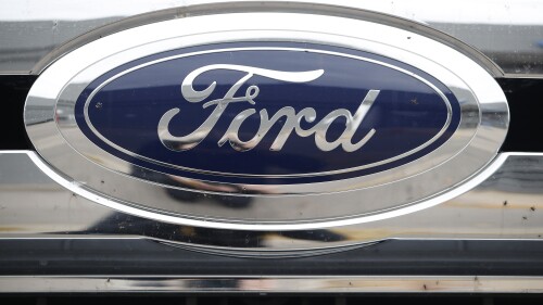 FILE - In this Oct. 20, 2019 file photo, the company logo shines off the grille of an unsold vehicle at a Ford dealership in Littleton, Colo. U.S. auto safety regulators are investigating complaints that the doors on some Ford Escapes can open while the SUVs are being driven. The investigation by the National Highway Traffic Safety Administration covers 346,000 Escapes from the 2020 and 2021 model years. The agency says in documents posted Tuesday, July 11, 2023 on its website that it has 118 complaints that spot welds in a door assembly bracket can fail. (AP Photo/David Zalubowski, File)
