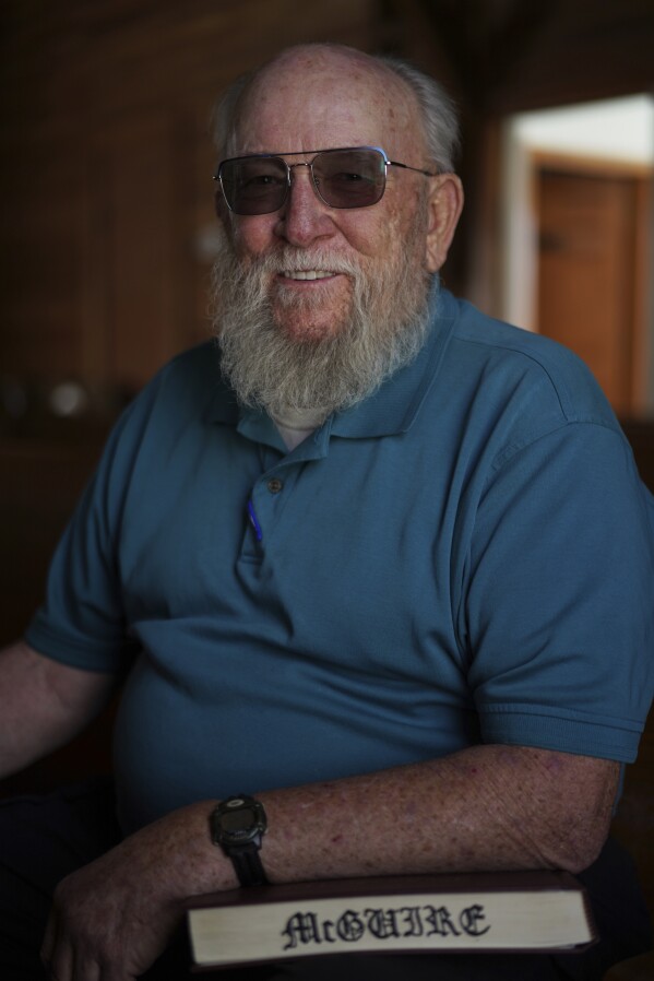 Oscar McGuire poses for a portrait with his copy of "The Sacred Harp" songbook at Holly Springs Primitive Baptist Church in Bremen, Ga., on Saturday, March 22, 2025. (AP Photo/Jessie Wardarski)