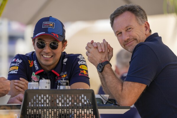 Red Bull team principal Christian Horner, right, chats with Red Bull driver Sergio Perez of Mexico at the pits during Formula One pre season test at the Bahrain International Circuit in Sakhir, Bahrain, Wednesday, Feb. 21, 2024. (AP Photo/Darko Bandic)