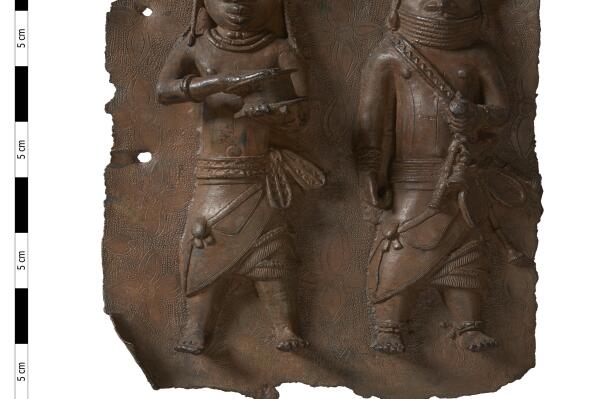 This handout photo provided by Horniman Museum and Gardens shows a brass plaque depicting a war chief and a royal military priest carrying a leather gift box. London's Horniman Museum and Gardens announced Sunday, Aug. 7, 2022 that it had agreed to return a collection of Benin Bronzes looted in the late 19th century from what is now Nigeria. (Horniman Museum and Gardens via AP)