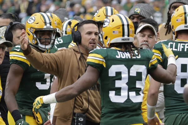 Green Bay Packers running back Aaron Jones (33) celebrates with head coach Matt LaFleur after scoring a 3-yard rushing touchdown during the first half of an NFL football game against the Los Angeles Rams, Sunday, Nov. 5, 2023, in Green Bay, Wis. (AP Photo/Mike Roemer)