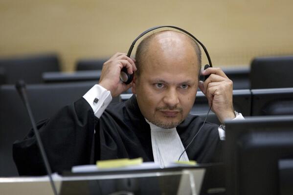 FILE  - In this Monday, June 4, 2007 file photo, lawyer Karim Khan adjust his headphones in the courtroom of the Special Court for Sierra Leone in The Hague, the Netherlands.  Khan is being sworn in Wednesday, June 16, 2021 as the new chief prosecutor of the International Criminal Court, taking leadership of a busy and financially stretched team that is probing alleged atrocities around the globe. Khan, a 51-year-old English lawyer, has years of experience in international lawyer as a prosecutor, investigator and defense attorney. He takes over from Fatou Bensouda of Gambia, whose nine-year term ended Tuesday. (AP Photo/Robert Vos, Pool, File)
