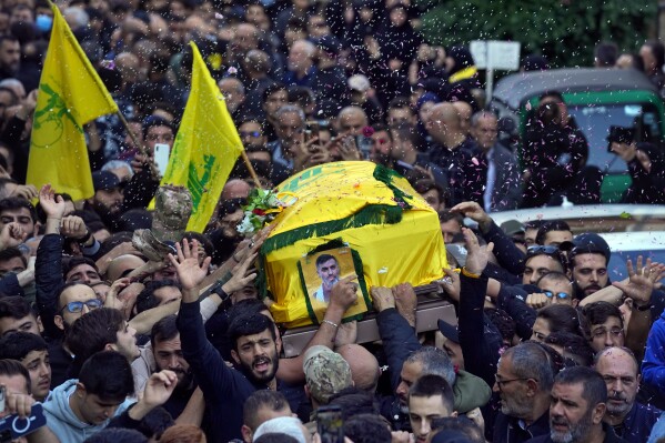 Mourners chant slogans as they carry the coffin of Abbas Mohammed Raad, the son of the head of Hezbollah's parliamentary bloc, Mohammed Raad, who was killed by an Israeli strike, during his funeral procession in the southern town of Jbaa, Lebanon, Thursday, Nov. 23, 2023. The militant Hezbollah group fired more than 50 rockets at military posts in northern Israel on Thursday, a day after an Israeli airstrike on a home in southern Lebanon killed five of the group's senior fighters. (AP Photo/Bilal Hussein)