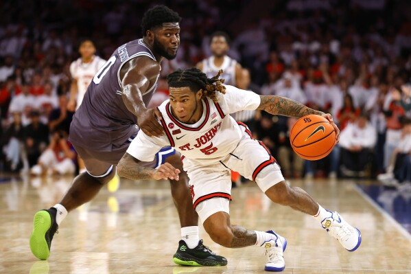 St. John's guard Deivon Smith (5) is fouled by Seton Hall guard Dylan Addae-Wusu (0) during the second half of an NCAA college basketball game, Saturday, March 1, 2025, in New York. (AP Photo/Noah K. Murray)