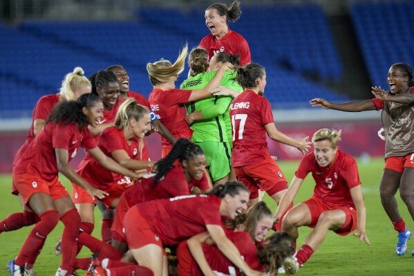 FILE - Canada player celebrate defeating Sweden for the gold medal in women's soccer at the Summer Olympics, Aug. 6, 2021, in Yokohama, Japan. The Canadians were humbled by a poor performance at last summer’s Women’s World Cup. Canada failed to advance out of the group stage for the first time since 2011. The disappointment came just two years after the team won Olympic gold at the Tokyo Games.(AP Photo/Fernando Vergara, File)